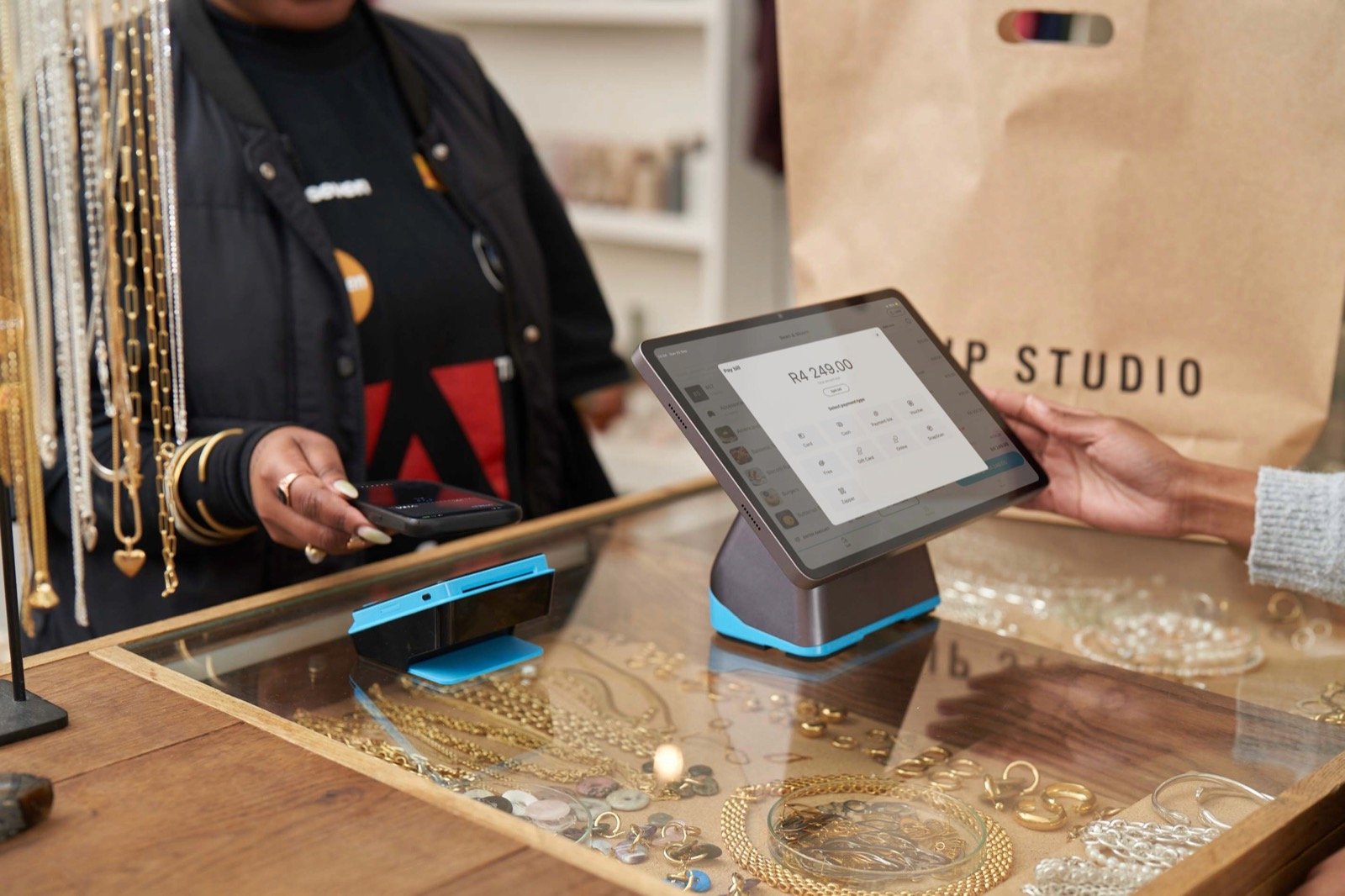 A restaurant customer paying with a blue Yoco card machine